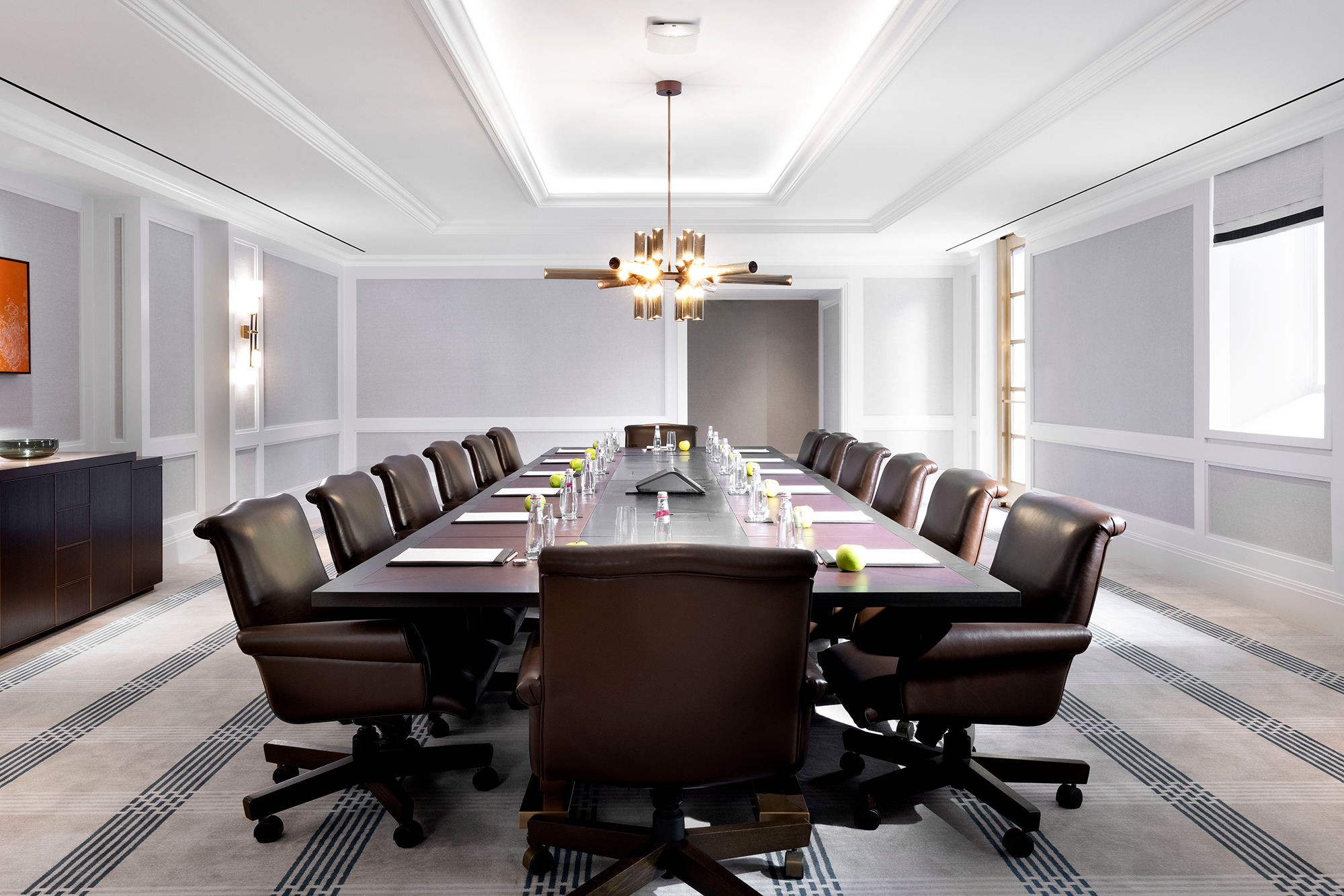 Mckinley - Meeting room - features a boardroom table, luxe leather chairs, a 75-inch HDTV, and a private terrace.