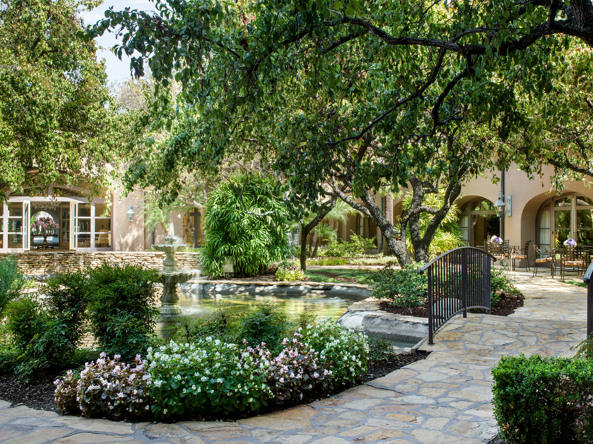 The Courtyard features lush greenery and a pond with a trickling fountain — perfect for a casual al fresco lunch or happy hour cocktails.